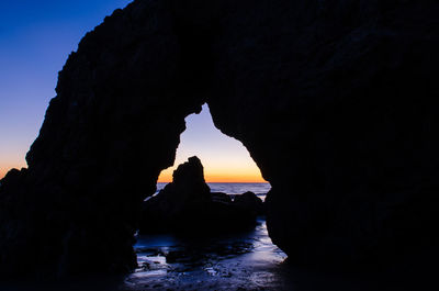 Silhouette of rock formations in sea