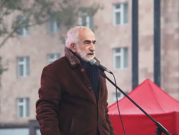 Mid adult man standing against built structure