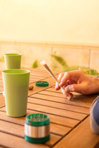 Cropped hand of person using mobile phone on table