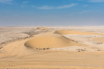 Sand dunes in desert against sky