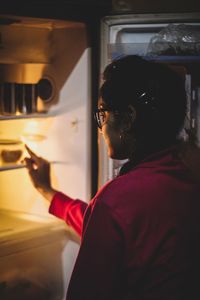 Woman standing by fridge at home