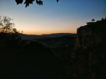 Scenic view of silhouette mountains against clear sky at sunset