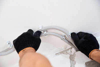 Midsection of person holding umbrella at home