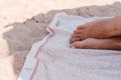 Low section of woman relaxing at beach