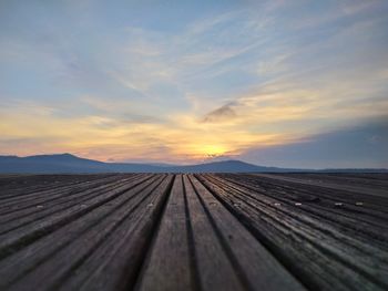 Boardwalk against sky during sunset