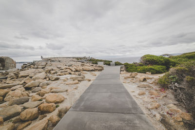 Footpath amidst rocks against sky