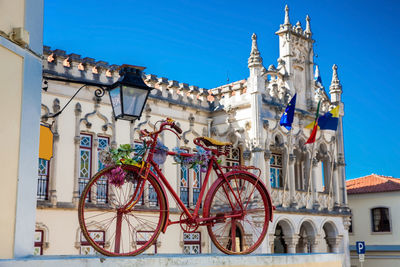 Old decorated bicycle and sintra town hall building on background in a beautiful sunny day