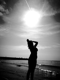 Sensuous woman posing on seashore against sky