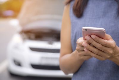 Midsection of man using mobile phone