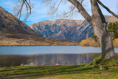 Scenic view of lake by mountains against sky