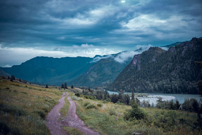 Scenic view of road by katun river and mountains against sky, altai, russia