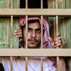 Portrait of young man looking through window