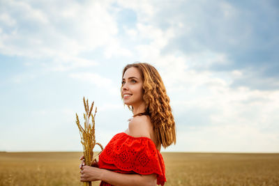 Young beautiful woman in golden wheat field. happy woman