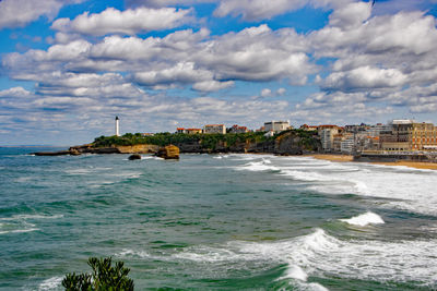 Scenic view of sea and buildings against sky