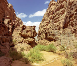 Rock formations on landscape against cloudy sky