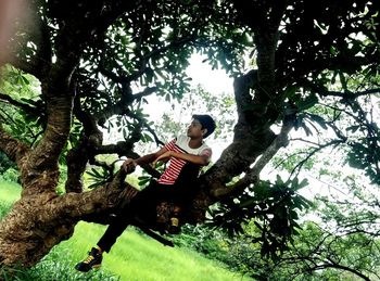 Man sitting by tree trunk