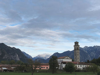 Houses by buildings against sky