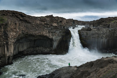 Scenic view of waterfall against sky