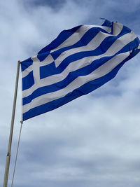 Low angle view of flag against cloudy sky