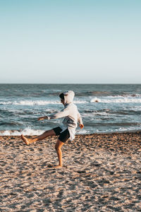 Full length of woman playing at beach