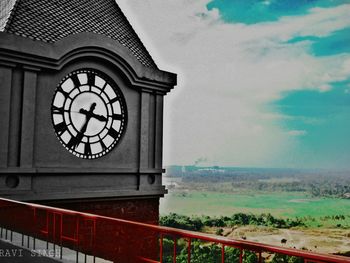 Low angle view of clock against sky