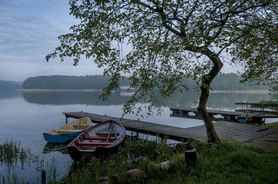 Boat moored at lakeshore against sky