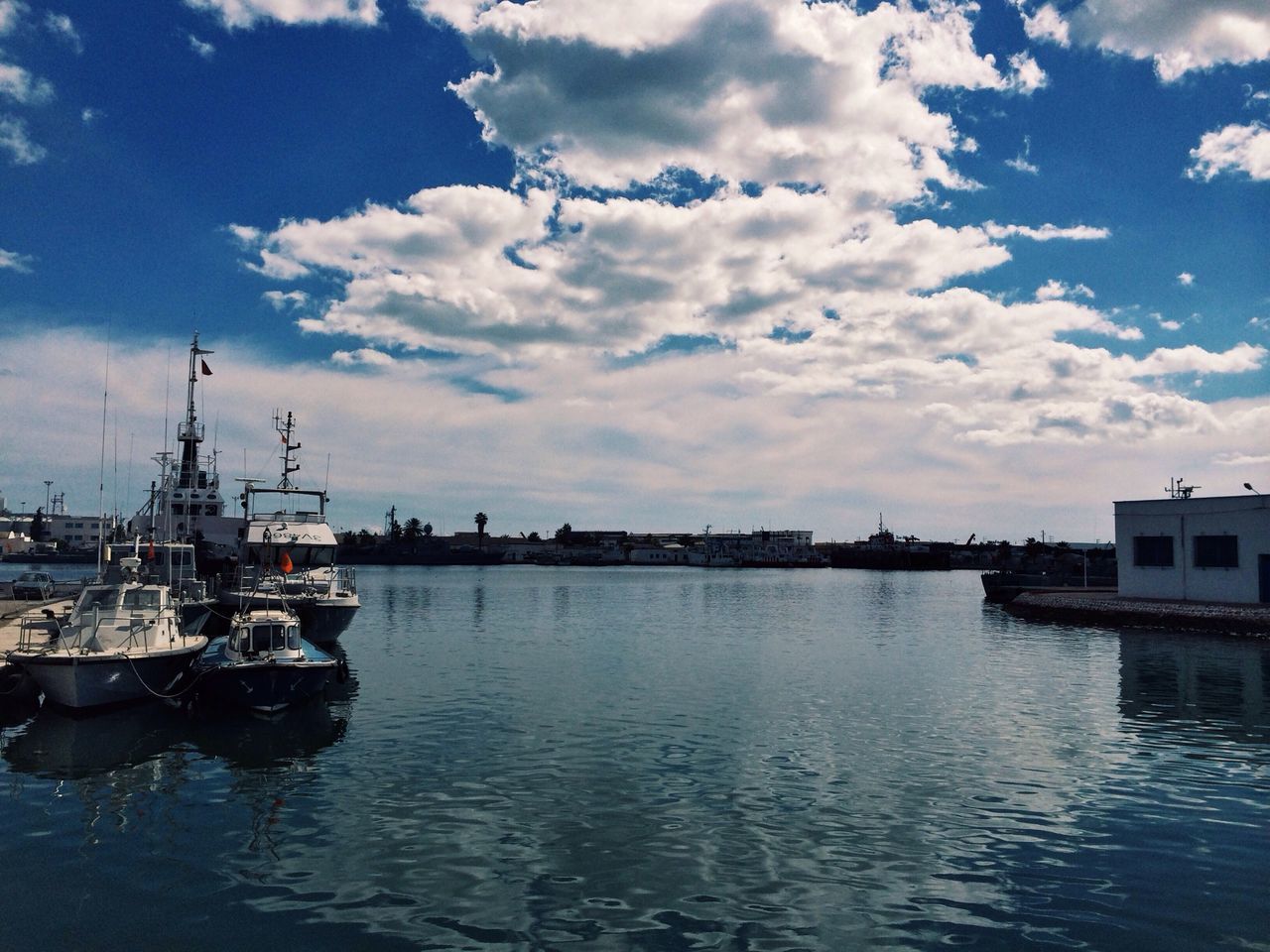 water, sky, nautical vessel, waterfront, cloud - sky, transportation, boat, mode of transport, cloud, moored, cloudy, rippled, reflection, harbor, building exterior, sea, river, built structure, tranquility, nature