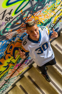 Full length of young man against graffiti wall