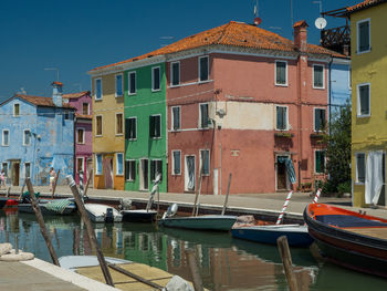 Boats moored at harbor against buildings in city