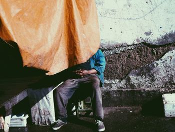 Low section of man sitting outdoors