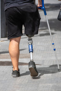 Person walking on the street with a prosthetic leg person