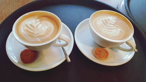 High angle view of cappuccino and coffee on table