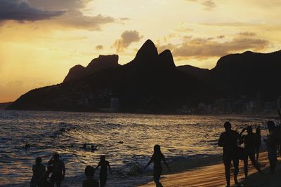 Silhouette people at beach during sunset