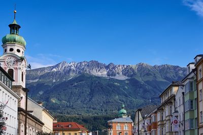 Panoramic view of buildings and mountains against clear blue sky