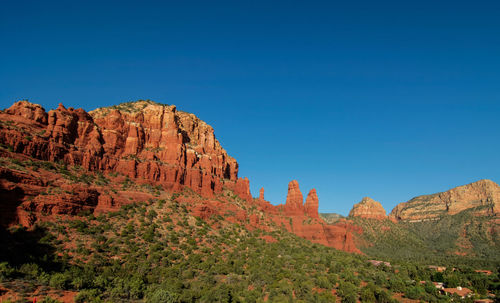 Rock formations on mountain against blue sky