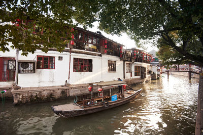 Boats in canal amidst buildings in city