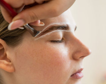 Close-up of young woman applying face