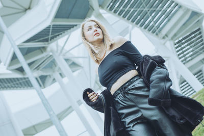 Low angle view of young woman standing in office building