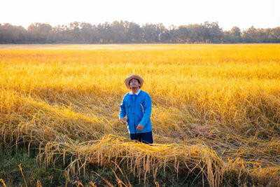 Portrait of man standing in field against sky