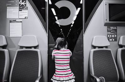 Rear view of girl standing in bus