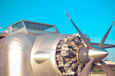 Low angle view of airplane against clear blue sky