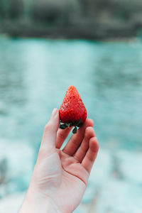 Close-up of hand holding strawberry