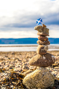 Stack of stones on beach against sky