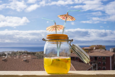 Close-up of drink at beach against sky