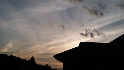 Low angle view of silhouette trees against sky