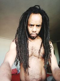 Portrait of man with dreadlocks at home