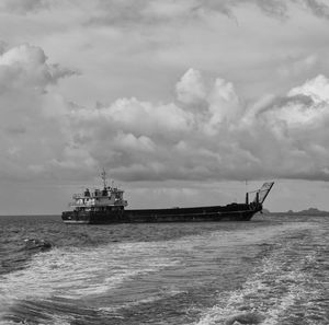 Ship sailing in sea against sky