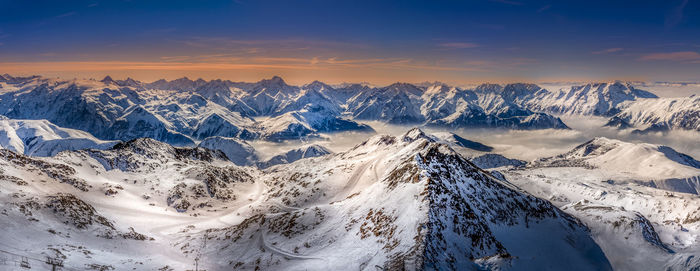 Panoramic shot of snowcapped mountains against sky during sunset
