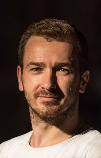 Portrait of young man against black background