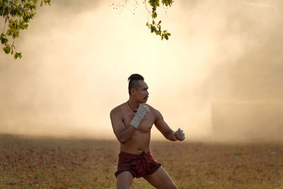 Full length of young man standing on field